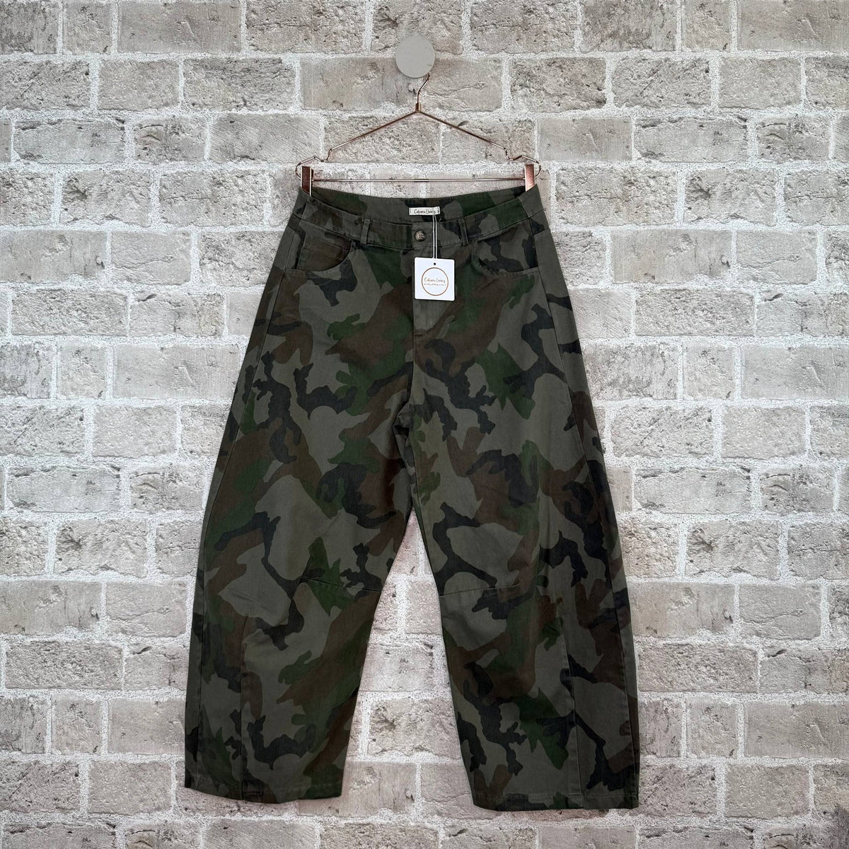 Cabana Living Wild Balo Army-mønstrede, brede, korte bukser med et grønt og brunt camouflagemønster, der hænger på en bøjle.