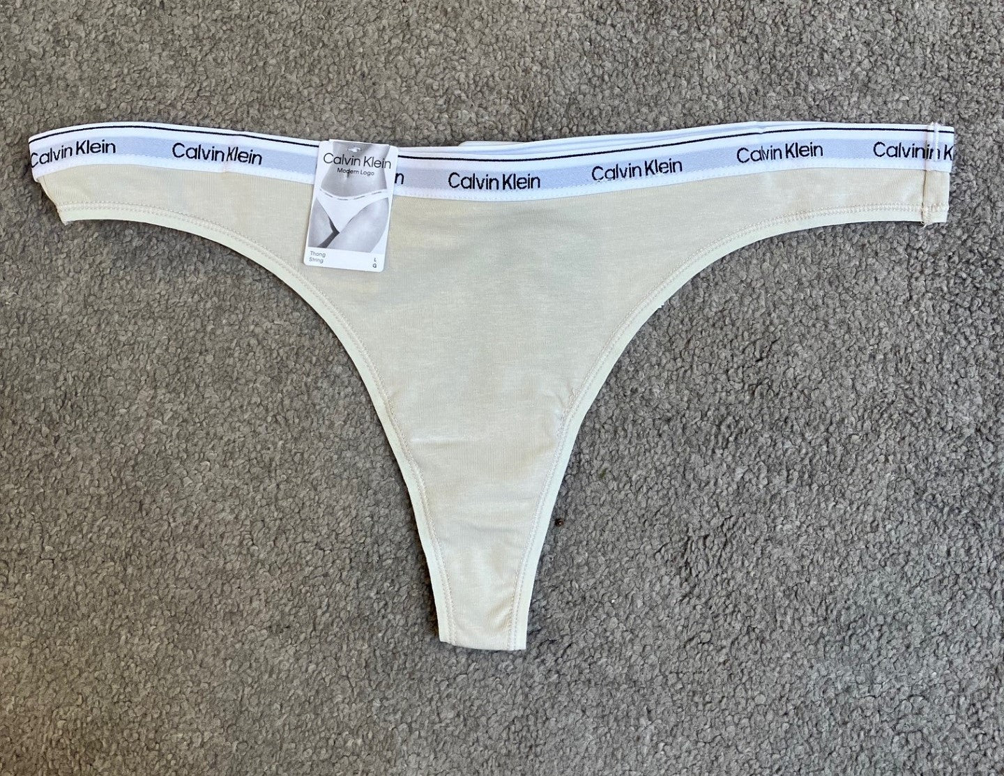 Calvin Klein beige G-streng, 149526, vist på et tæppe; tilbud: 3 for 399,-.