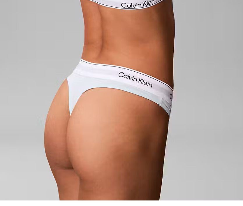 En person set bagfra iført et sæt fra Calvin Klein - Feel The Mint Mint-kollektionen, foran en ensfarvet grå baggrund.