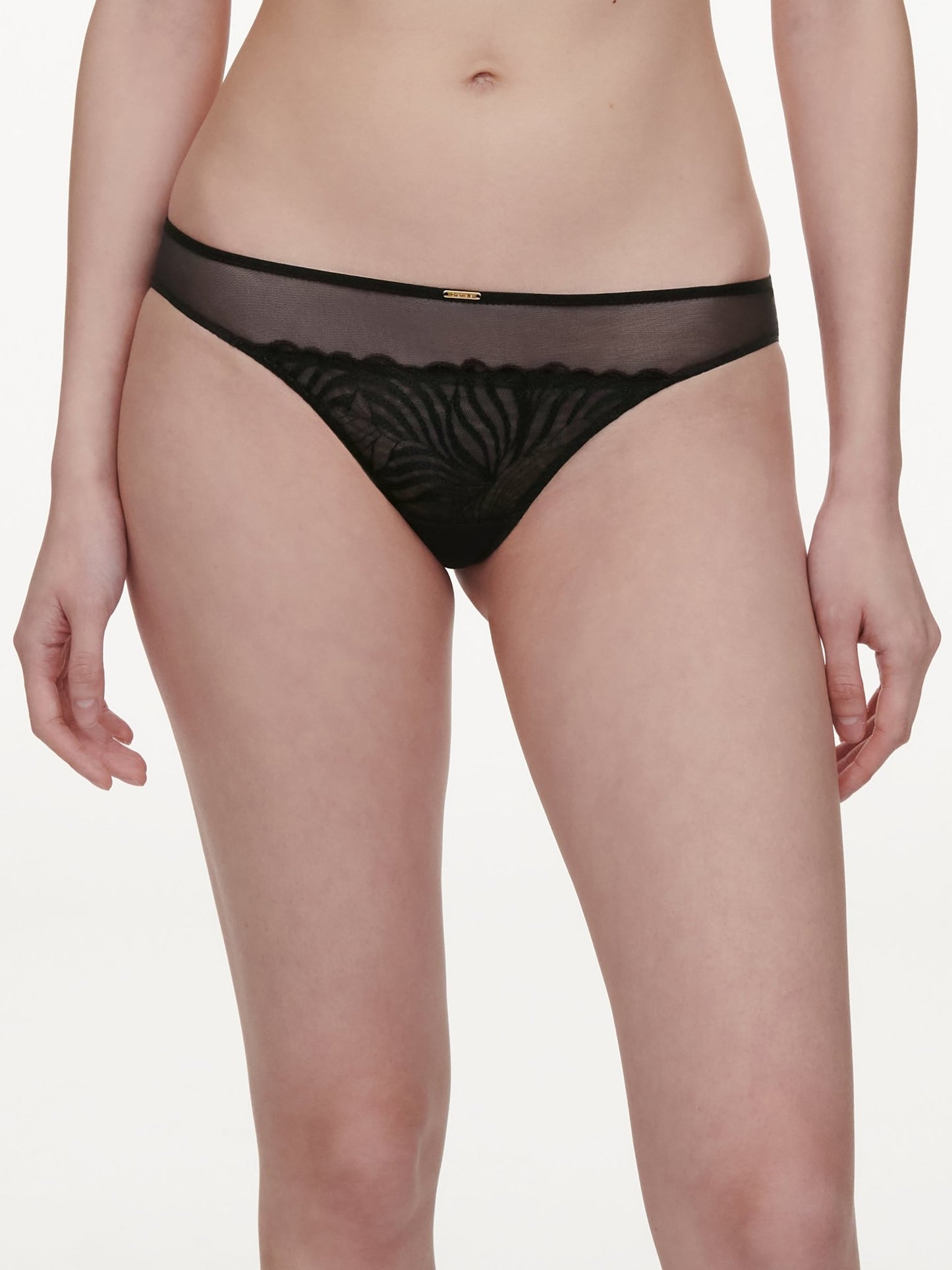 Modellen bærer en Chantelle 153823 Legend Black Sort mesh-g-streng; overkroppen og de øverste dele af benene vises på en hvid baggrund.