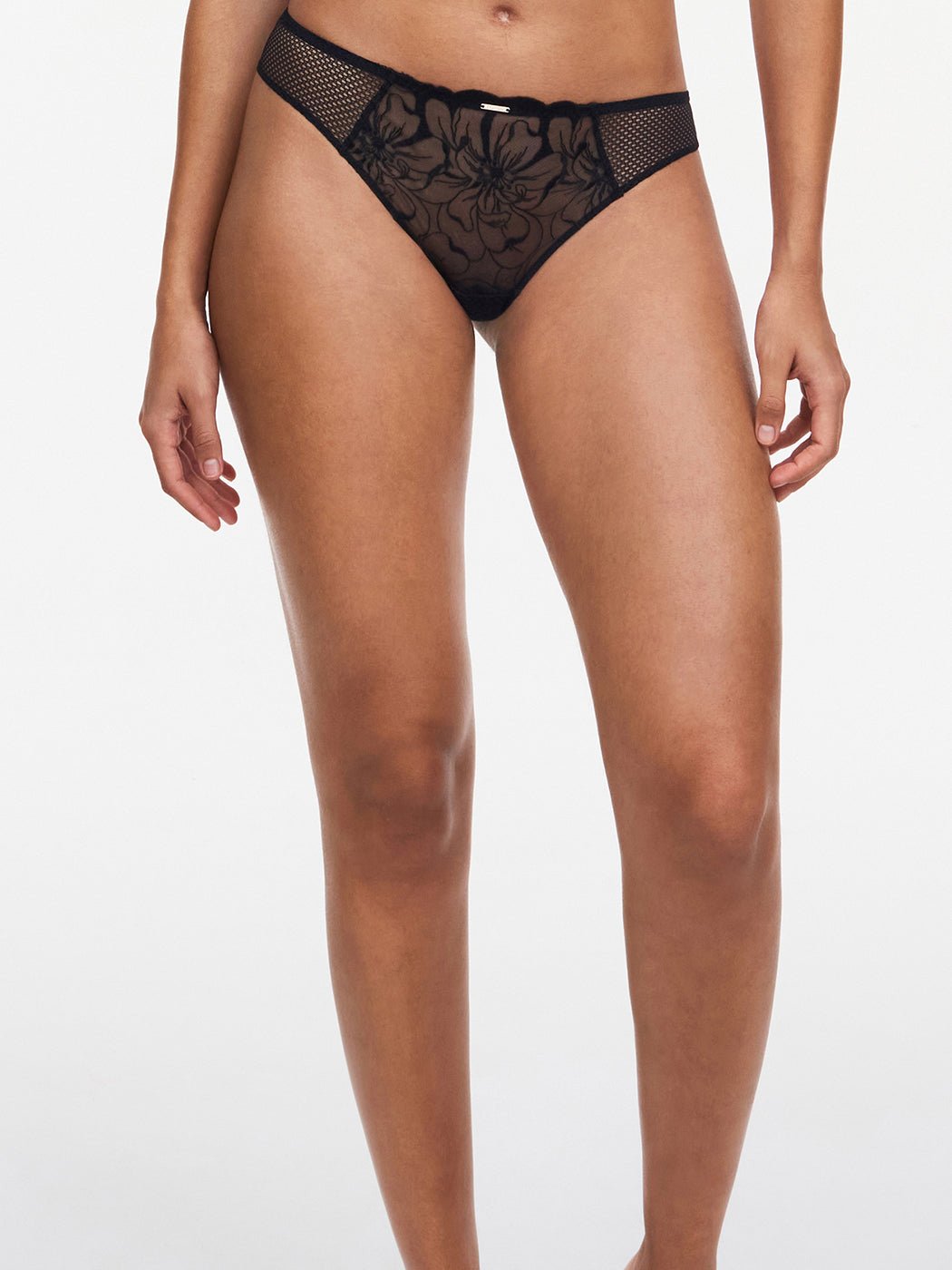 En model bærer Chantelle Fleurs Black Sort-trusser, der vises fra midten af overkroppen til midten af låret på en ensfarvet baggrund.