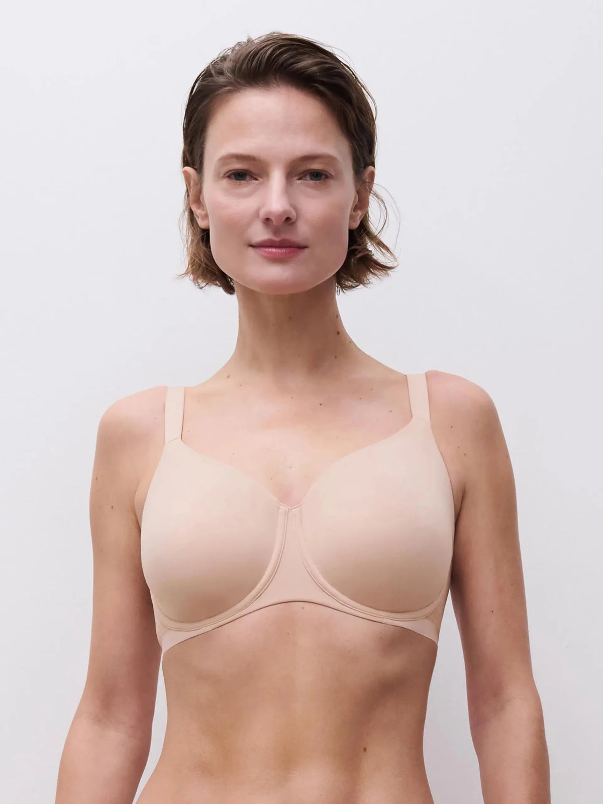 Modellen bærer en Chantelle EasyFeel 150414-bh med fulde skåle i farven pudder, der giver optimal dækning og har feminine blondedetaljer.