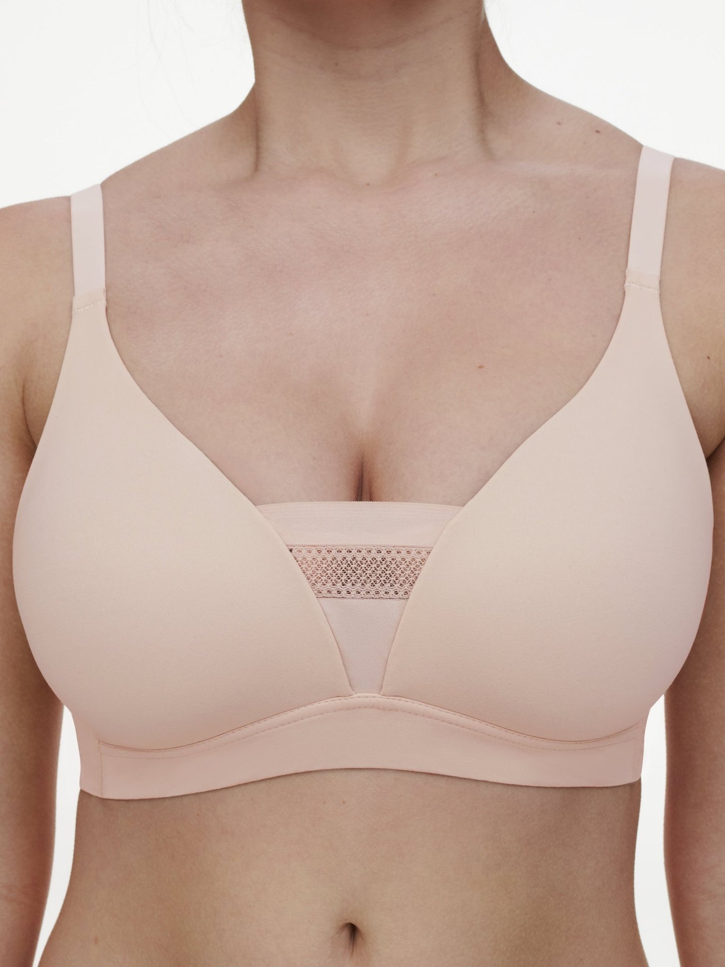 En kvinde har Chantelle EasyFeel 152526 Easy Bliss-bhen på i farven Golden Beige Pudder med et netindsats i midten.