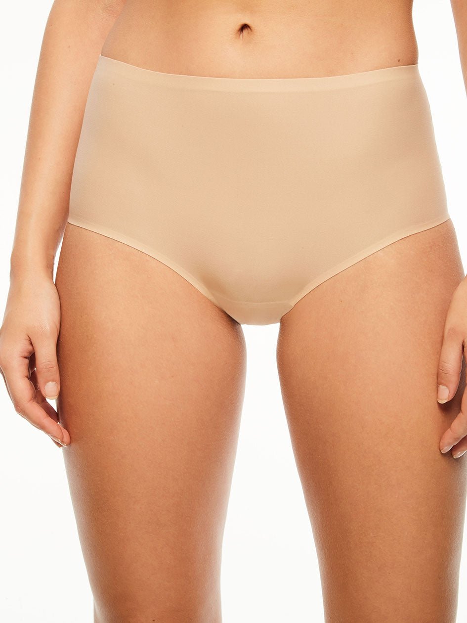 Model iført Chantelle Seamless Soft Stretch Maxi Sand, en nudefarvet shaper med høj talje, vist fra taljen til midt på låret.