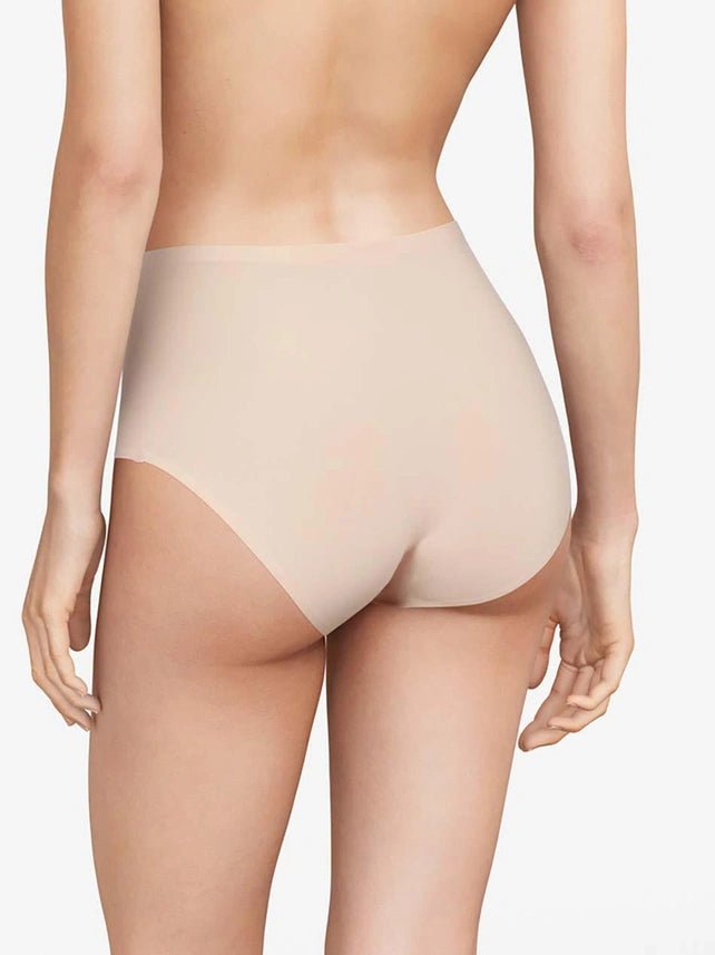 Bagfra-billede af en person, der bærer Chantelle Seamless - Soft Stretch Maxi Sand-trusser i nudefarve på en ensfarvet baggrund.