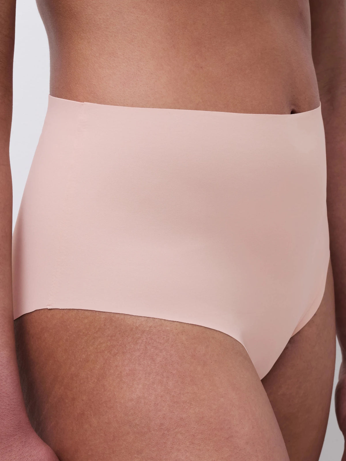 Dette billede viser en person, der bærer Chantelle Seamless – Defi Pudder, nudefarvede, sømløse maxi-trusser fra Chantelle Seamless.