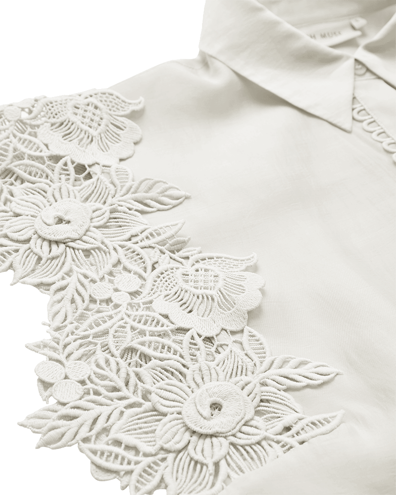 Nærbillede af Copenhagen Muse Molly Off White-skjorte med blomsterbroderi i blonder på den ene skulder.