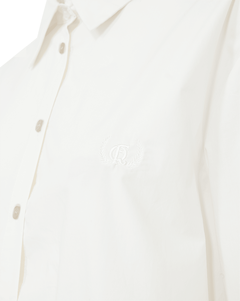 Nærbillede af Freequents Jolle Hvid-skjorte – off-white med broderet monogram og laurbærkrans på brystet.