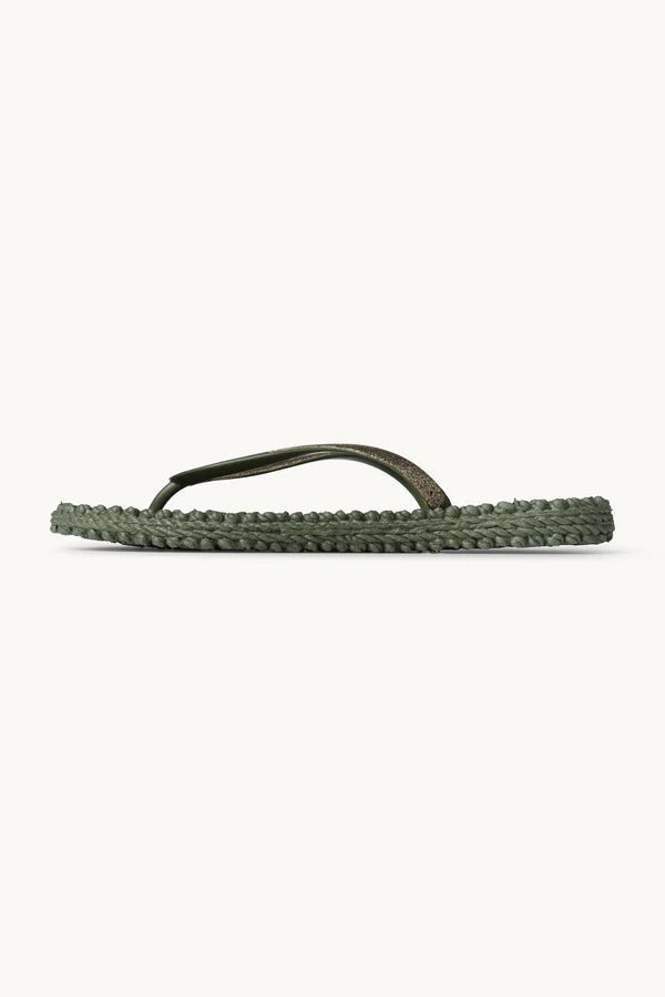 Ilse Jacobsen grønne glitter-sandaler, flettet sål, tynde remme, set fra siden på en ensfarvet baggrund.