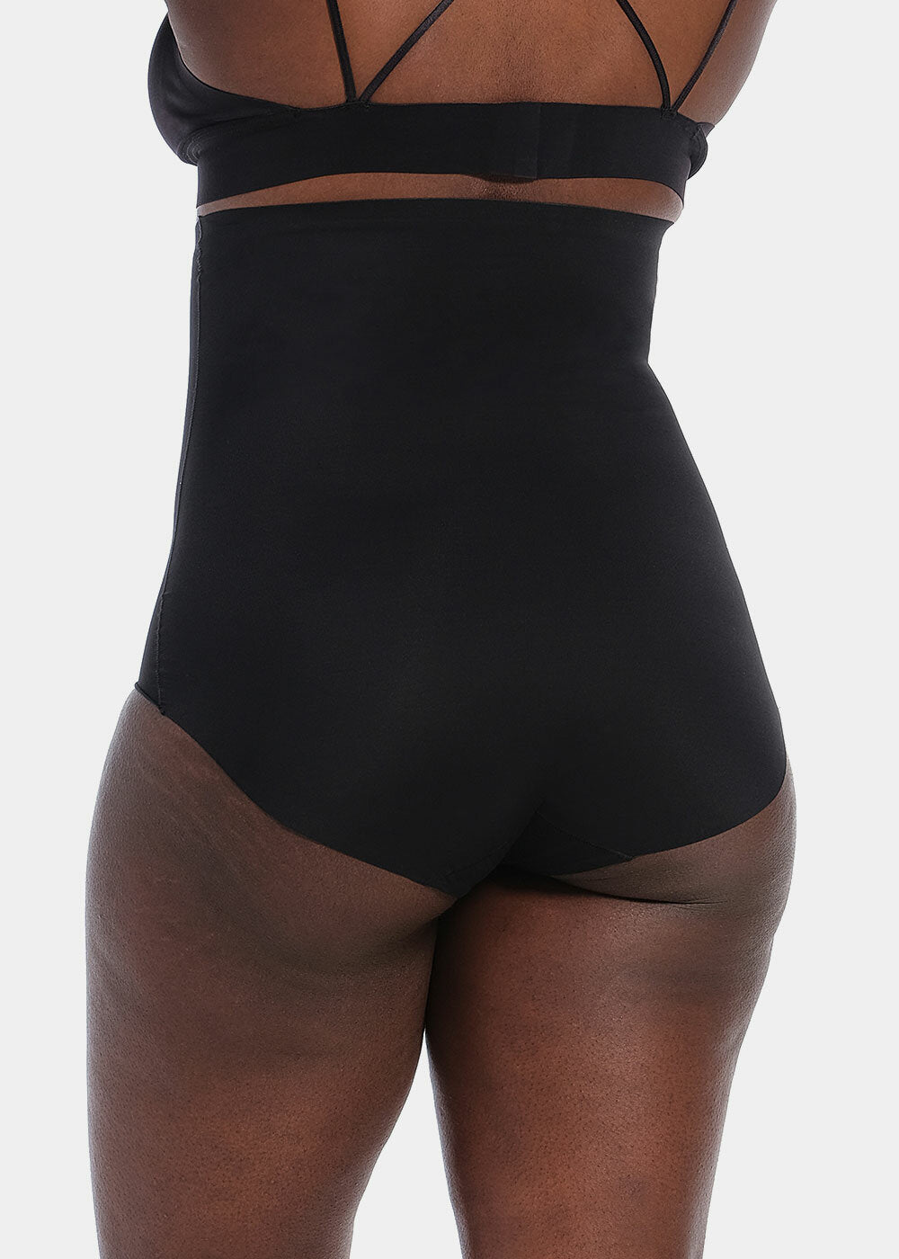 Modellen bærer Magic Bodyfashion Maxi Sexy Hi-Brief Sort, set bagfra, på en ensfarvet hvid baggrund.