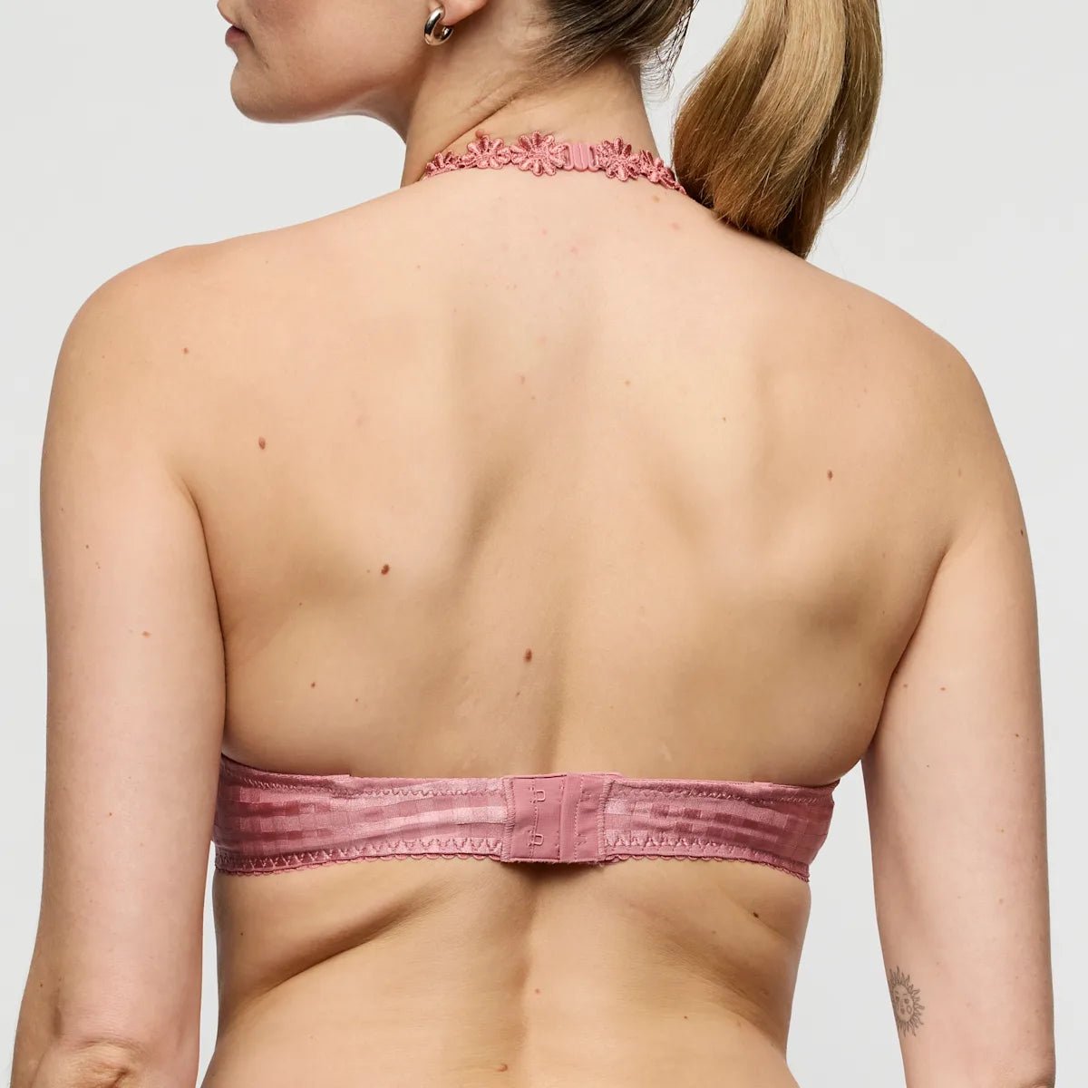En kvinde set bagfra iført en lyserød »Gammelrosa«-bh fra Marie Jo Avero Ballet og en blomstret choker-halskæde.