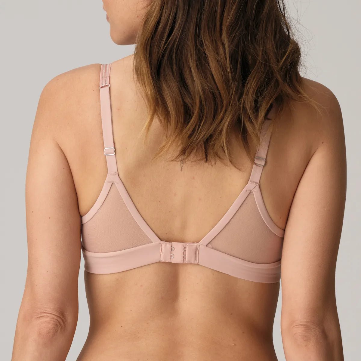 Bagfra set billede af en støvrosa Marie Jo – LOUIE Powder Rose Rosa-bh med gennemsigtige mesh-paneler og justerbare stropper.