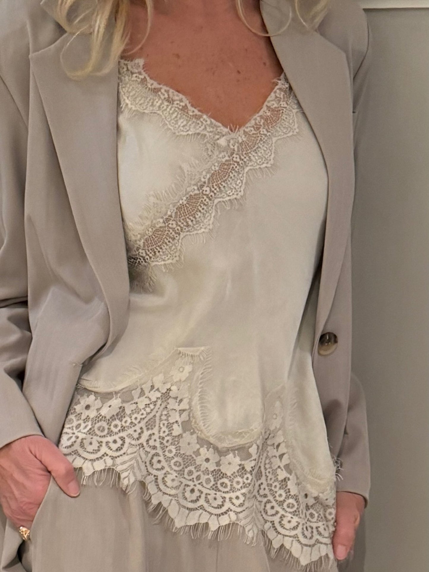 En person iført en 153684 Marta du Château - Dream Beige-jakke over en Marta du Château-top, med hånden i lommen.