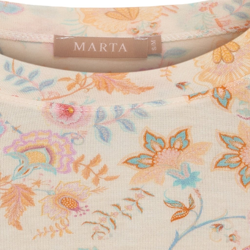 Nærbillede af Marta du Château Elissa Beige langærmet T-shirt med pastelfarvet blomsterprint og mærkelabel ved halsen.