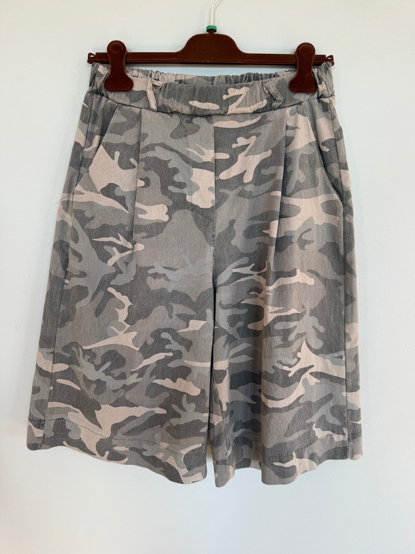 Marta du Château Zuri Army-grønne shorts hænger på en mørk træbøjle foran en hvid baggrund.