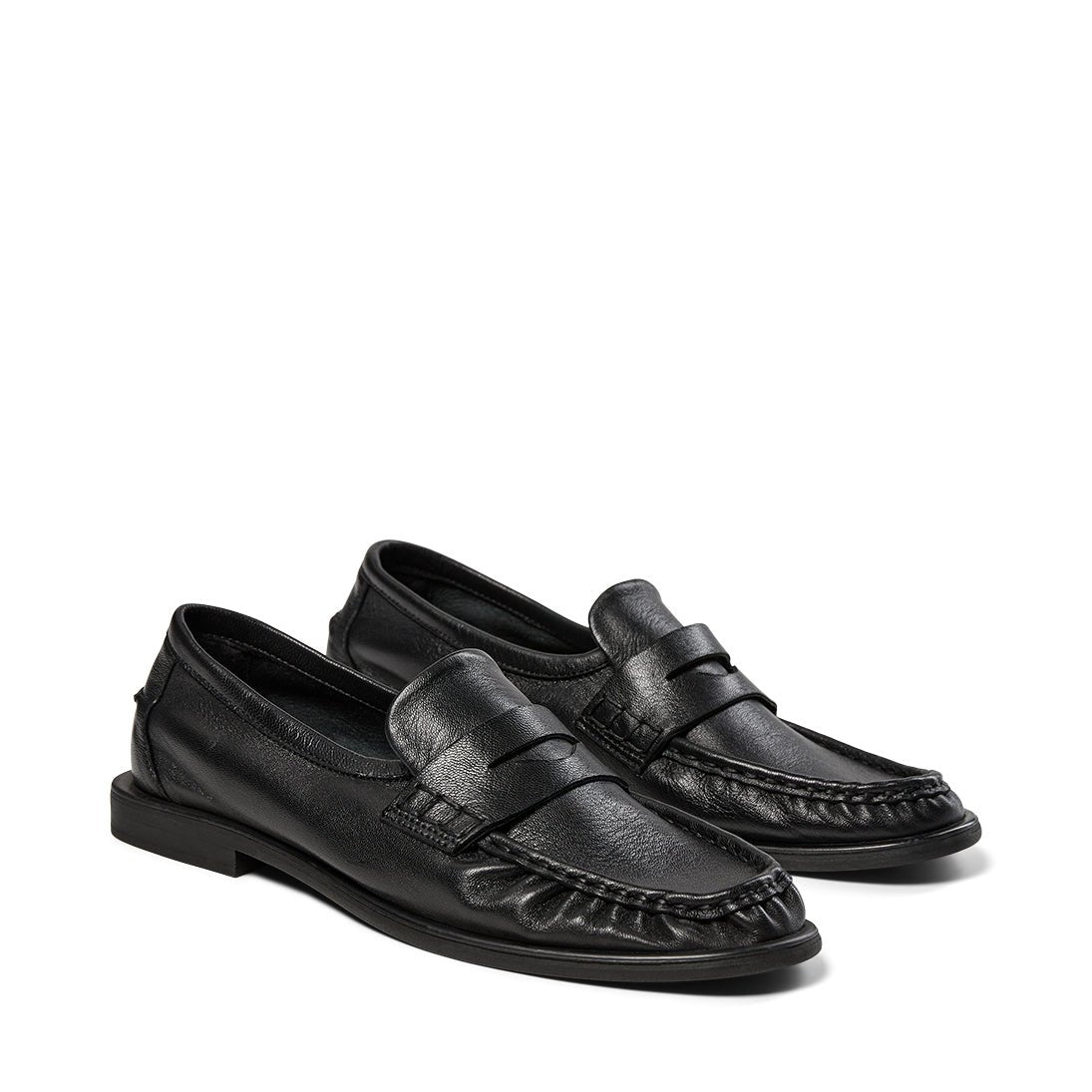 PAVEMENT Elmira Sort loafer i sort læder med moc-tå-søm og penny-rem, vist på hvid baggrund.