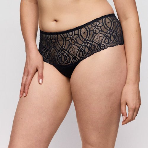 Modellen bærer en PrimaDonna Salerno Midnight Blue-string med høj talje, der dækker fra maven til låret, foran en ensfarvet baggrund.
