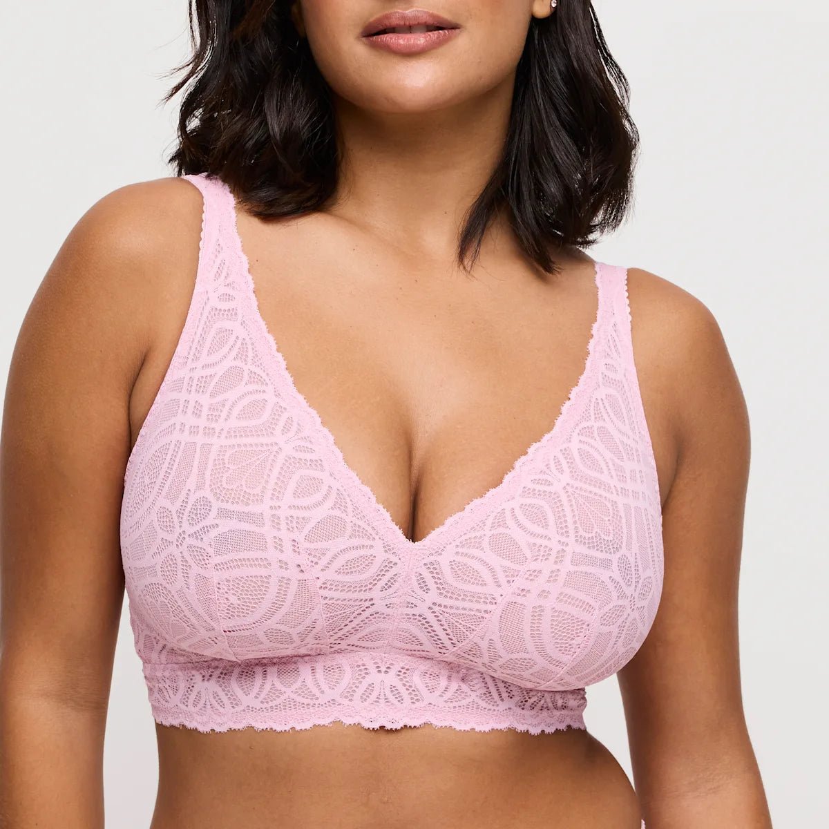 Modellen bærer en PrimaDonna Salerno Spring Rose Lyserød bralette, fra skuldrene til taljen, foran en neutral baggrund.