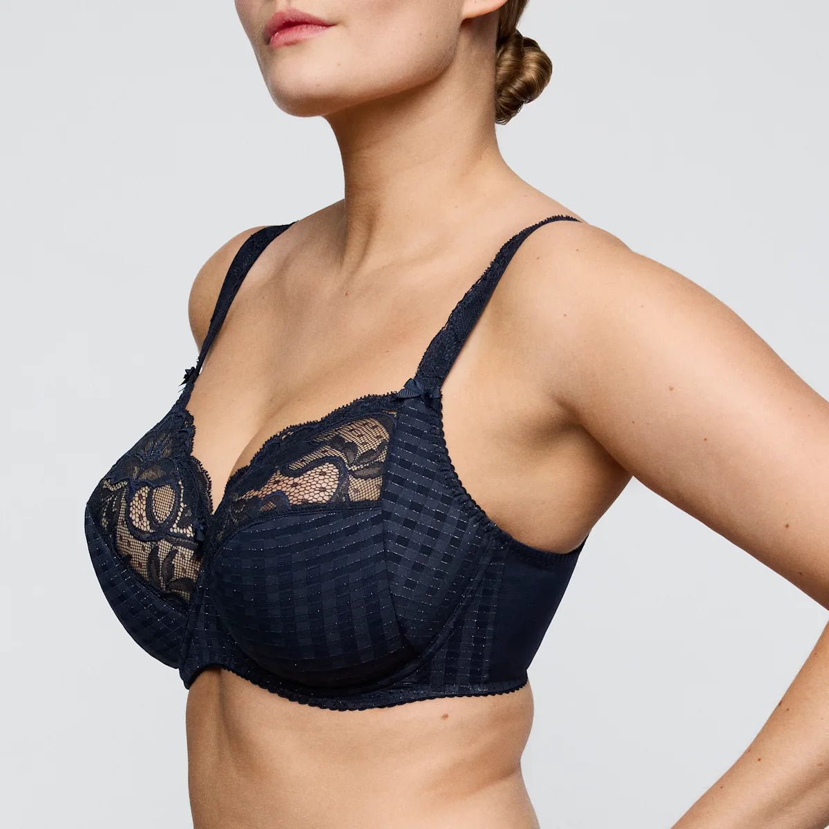 Model iført PrimaDonna Madison 155166 Velvet Blue-bh med blonder og bøjler, vist fra skuldrene til taljen.
