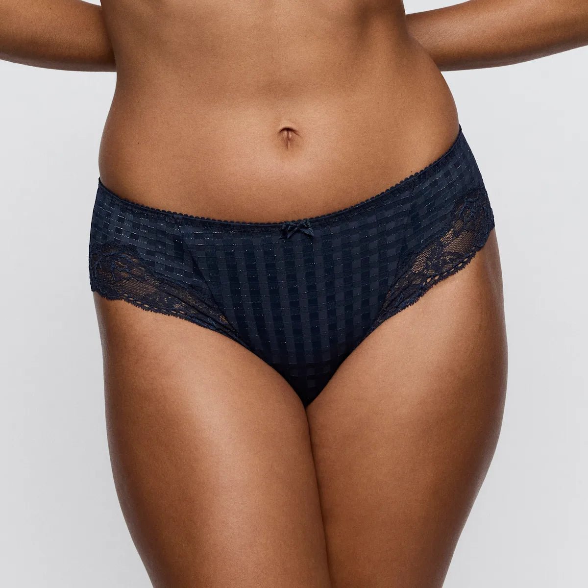 Model iført PrimaDonna Madison Velvet Blue 155169 hipster, blonde-detaljer, fra midten af overkroppen til lårene, ensfarvet baggrund.