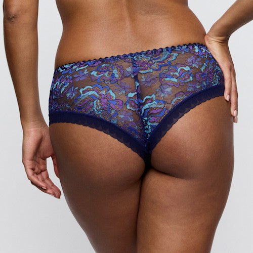 Model i gennemsigtig tyl, iført PrimaDonna San Angel Water Blue 155360 g-streng, set bagfra.