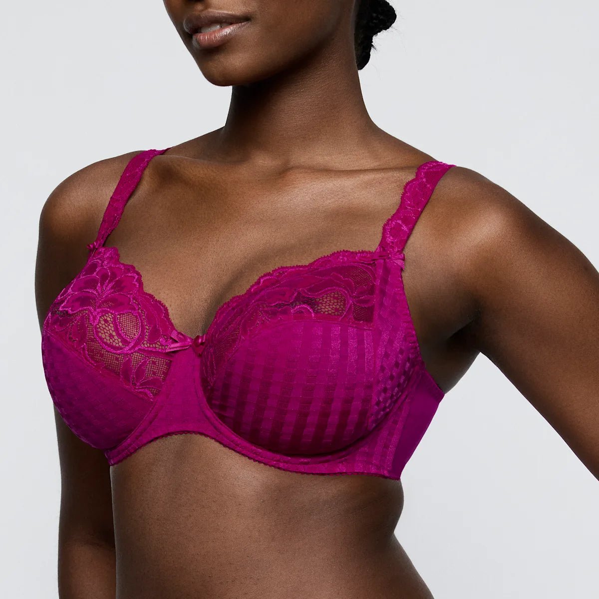 Model iført en PrimaDonna Madison Wild Rose Lilla-bh, fotograferet fra skuldrene til maven på en ensfarvet lys baggrund.