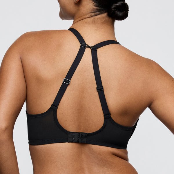 Kvinde iført en PrimaDonna Twist Sheary Black racerback-bh med net, set bagfra; justerbare stropper og hægte-lukning.
