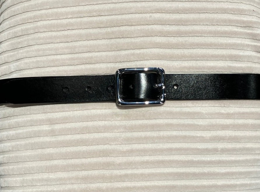 The 152403 | Vanzetti – Workwear Staples: sort læder, sølvspænde, på en ribbet, lys baggrund.