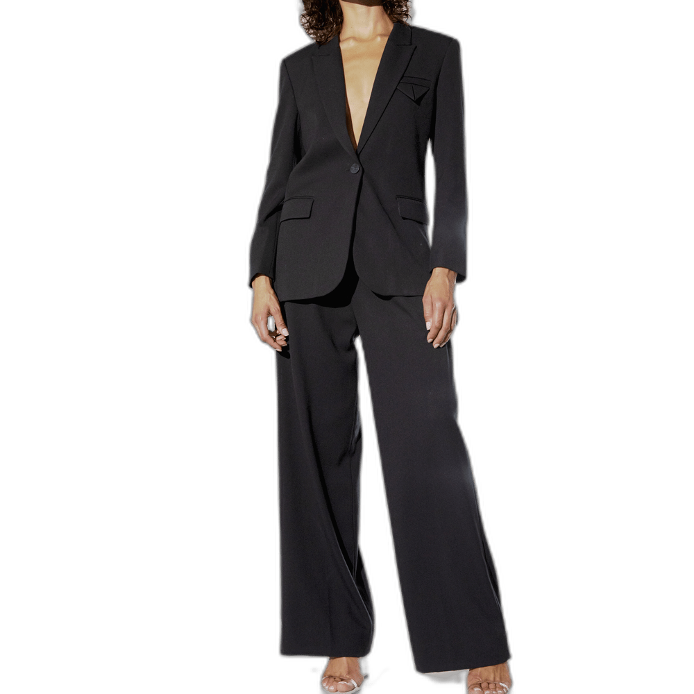 Model i København iført Muse Tailor-bukser med brede ben og en blazer, fotograferet foran en hvid baggrund.
