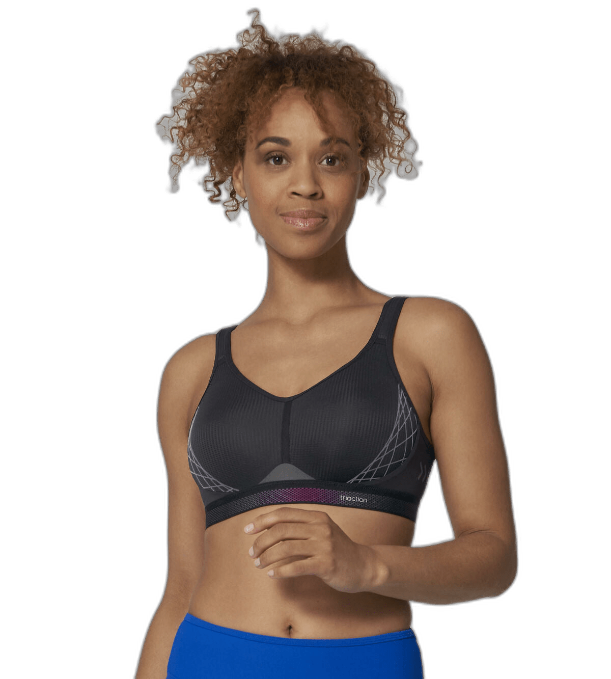 Kvinde iført en sort Triumph Triaction 136811 sports-BH og blå leggings, stående foran en hvid baggrund, vendt fremad.