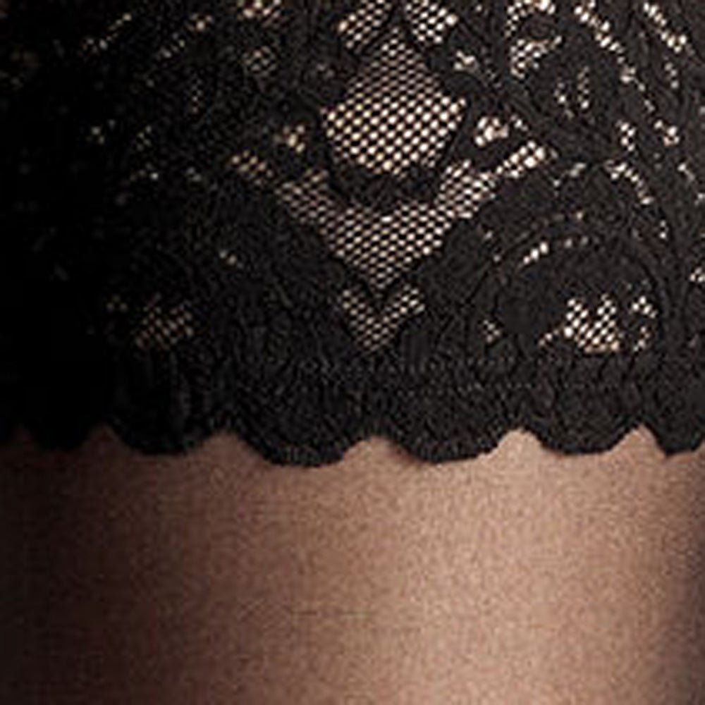 Nærbillede af Wolford Satin Touch 20 Black W: sort blonder, blomstermønstre, bølget kant over gennemsigtigt nylon.